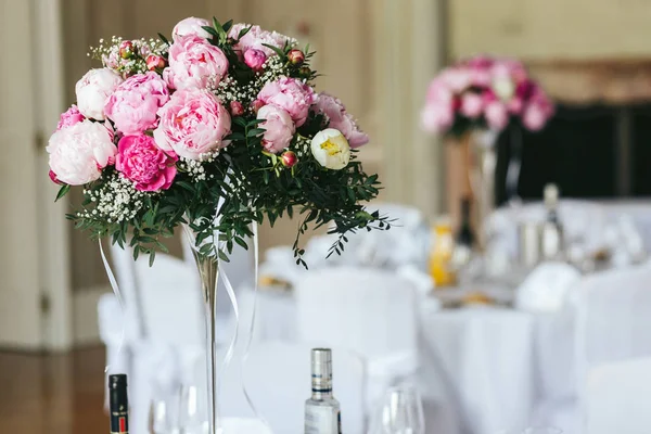 Bohatá kytice růžové pivoňky stojí na jídelním stole — Stock fotografie