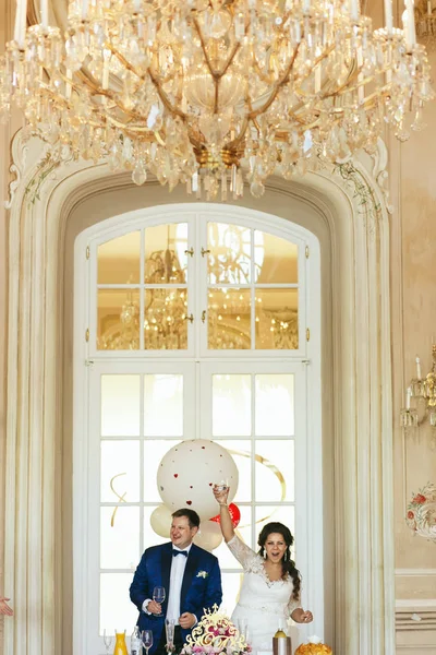Жених и невеста стоят перед стеклянной дверью, бросая что-то — стоковое фото