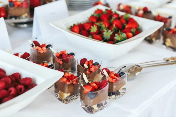 Chocolate desserts with strawberries stand on the white dinner t — Stock Photo, Image