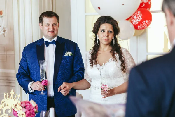 Snygg brud och brudgum stå tankeväckande med champagne flöjter — Stockfoto