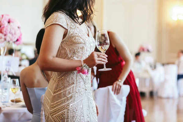 Lady in beige dress holds a champagne flute — Stock Photo, Image