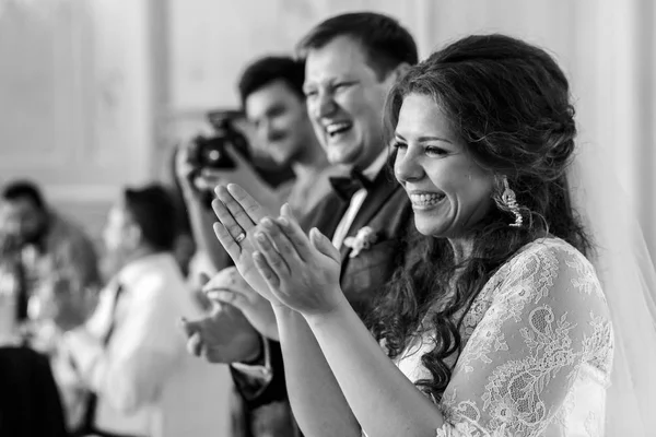 Applaudierendes Hochzeitspaar steht am Esstisch — Stockfoto