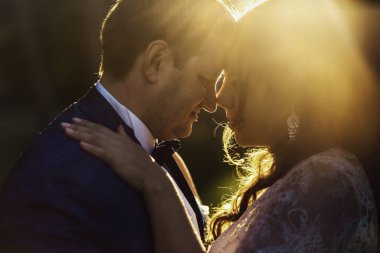 Gelin ihale kollarını damadın geniş omuzları üzerinde yatıyor.