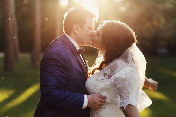 Braut breitet ihre Hände aus, während der Bräutigam sie zärtlich küsst — Stockfoto