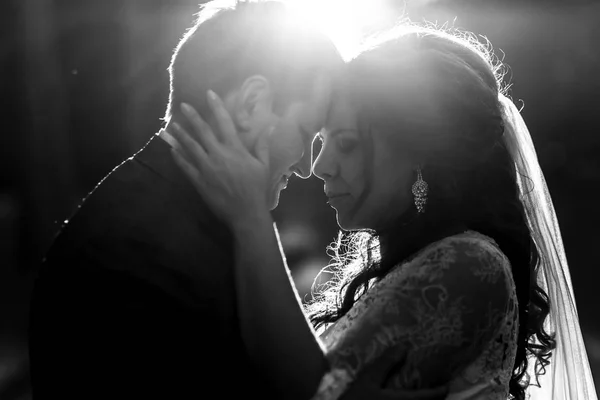 Black and white picture of bride holding groom's head while they — Stock Photo, Image