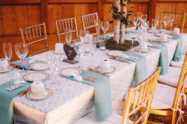 Bly ile beyaz dantel masa örtüsü üzerinde ahşap masa numarası duruyor