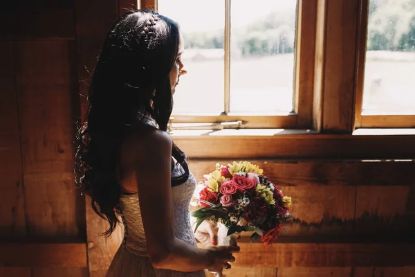 Sol brilla sobre una mujer morena de pie con ramo de bodas b —  Fotos de Stock