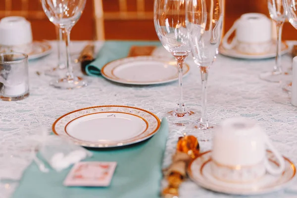 Vaisselle blanche avec support design doré sur la nappe bleue — Photo