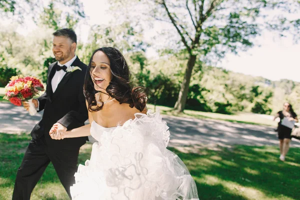 El viento sopla el pelo de la novia mientras ella sostiene la mano del novio durante un wa — Foto de Stock