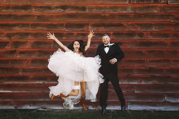 Feliz novia extiende sus manos mientras salta en botas de vaquero behi — Foto de Stock