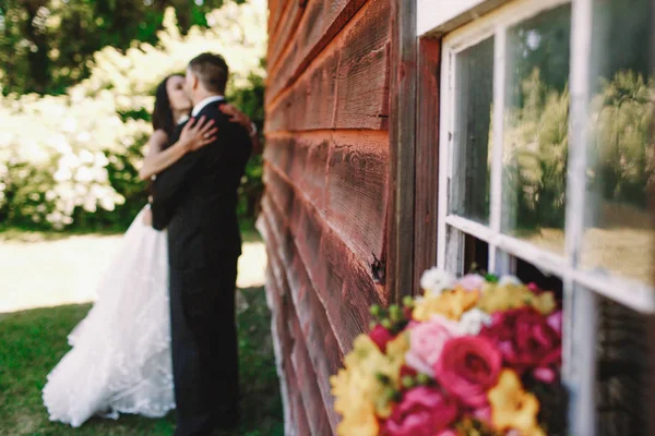 Bouquet de mariage lumineux se trouve sur le rebord de la fenêtre à l'extérieur tandis que la mariée — Photo