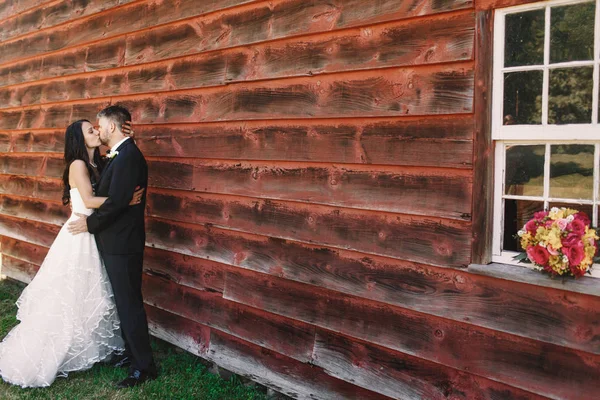 Braut streichelt dem Bräutigam den Kopf, während sie ihn zärtlich küsst — Stockfoto