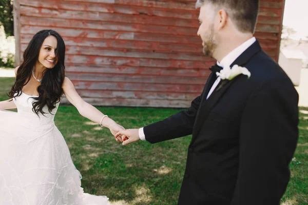 Merveilleuse brune mariée étire la tête du marié tout en marchant al — Photo