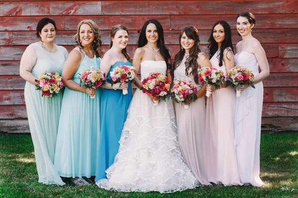 Damas de honor sonrientes en pie vestido de pastel en diferentes lados o —  Fotos de Stock