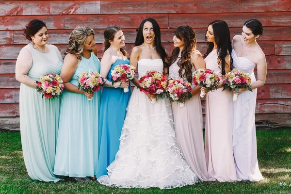 Belas damas de honra olham para uma noiva engraçada sorrisos enquanto posam — Fotografia de Stock