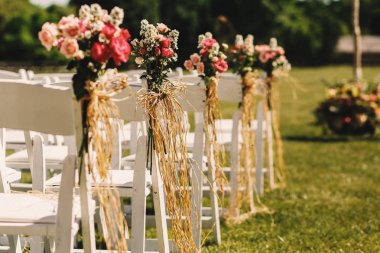 Pembe buketleri beyaz sandalyeler hang halatlar ile bağlı