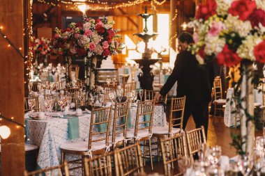 Adam akşam yemeği hangarda duran tablolarda peçeteler ayarlar