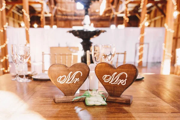 Wooden hearts with letterings 'Mr' and 'Mrs' stand on the dinner — Stock Photo, Image