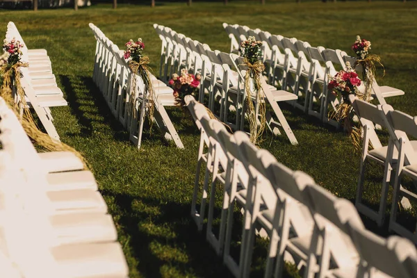 Λευκές καρέκλες ψέμα τη σκιά τους πάνω από το πράσινο πεδίο — Φωτογραφία Αρχείου