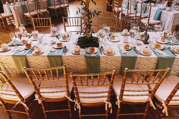 Cadeiras de bambu em pé à mesa de jantar decorada com serviço azul — Fotografia de Stock