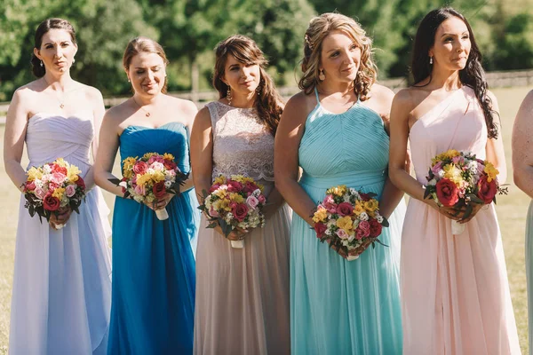Leende tärnor i pastell klänning står i rad bakom br — Stockfoto