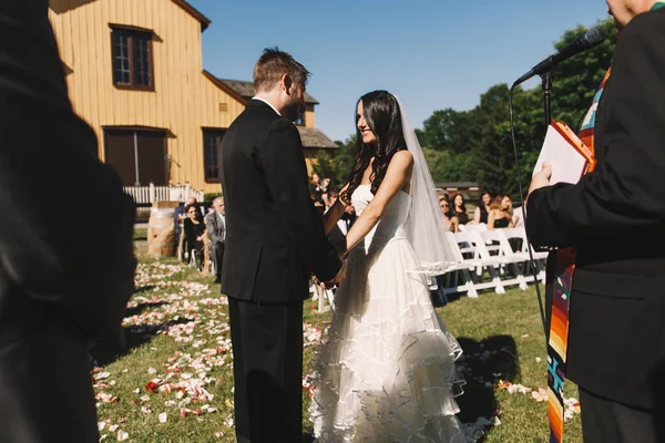 Жених восхищается красивой невестой, держа ее за руки во время — стоковое фото