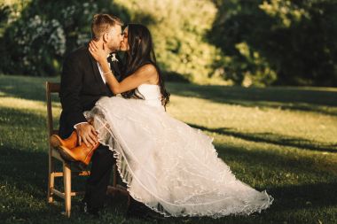 Gelin bacaklarını botlarla damadın kees üzerinde ou otururken tutar