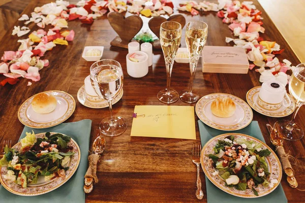 Πλάκες με τις σαλάτες και τα ψωμάκια στέκονται στο τραπέζι του δείπνου που παρασκευάζεται στ — Φωτογραφία Αρχείου