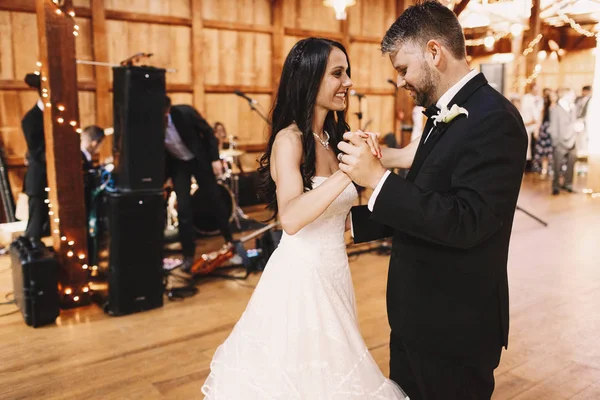 Bruidegom stappen voorzichtig tijdens het dansen met aantrekkelijke brunette brid — Stockfoto