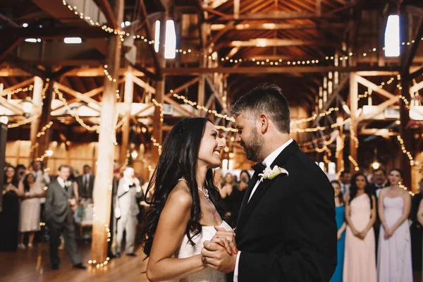 Felices recién casados se admiran mientras bailan en la ha de madera — Foto de Stock