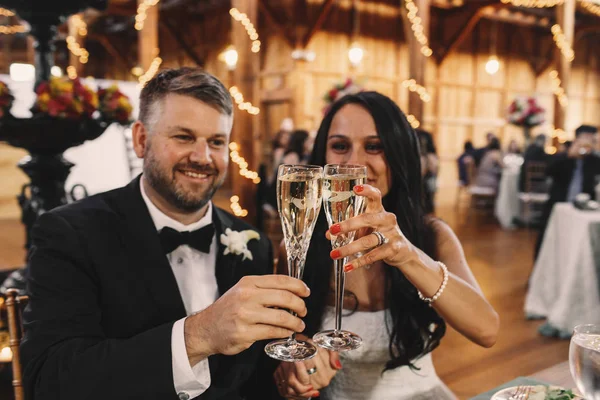 Recién casados chocan sus flautas de champán de cristal — Foto de Stock
