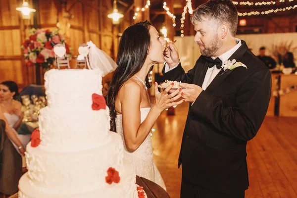 Mariée ouvre la bouche pour prendre un gâteau de la fourchette du marié — Photo