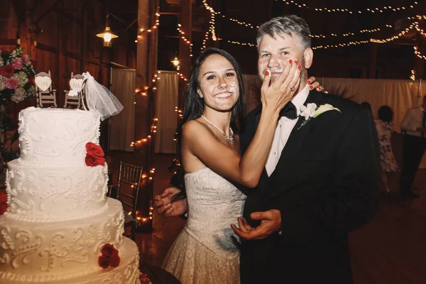 Bride caresse le visage du marié avec ses doigts en glaçure blanche douce — Photo