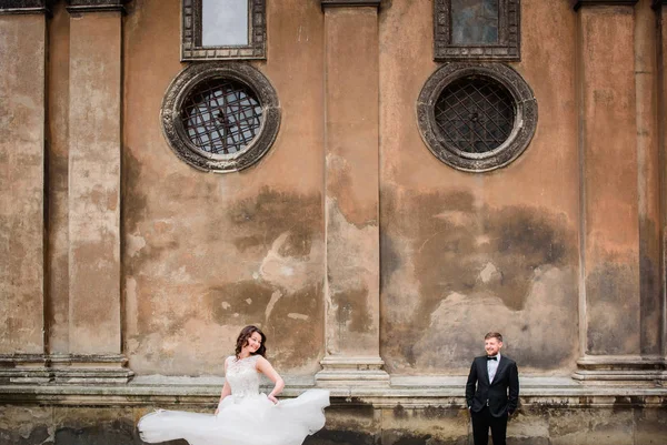 Šlehačkovou nevěsta před ženicha pózuje na ulici — Stock fotografie