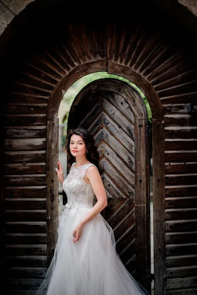 La mariée sort des portes en bois — Photo