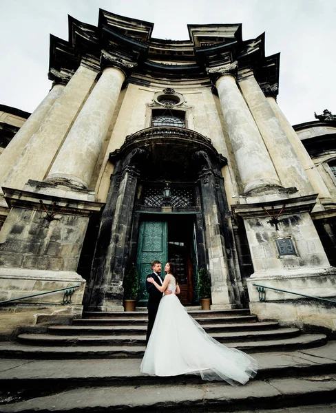 Titta nedan på bröllopsparet stående framför kyrkan — Stockfoto