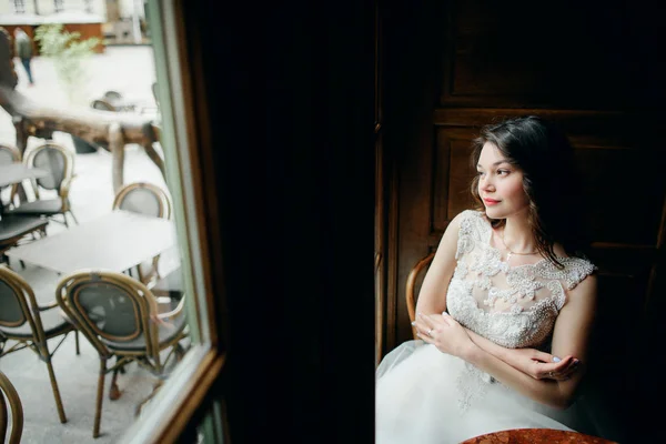 Jolie mariée assise sur la chaise dans la chambre noire — Photo