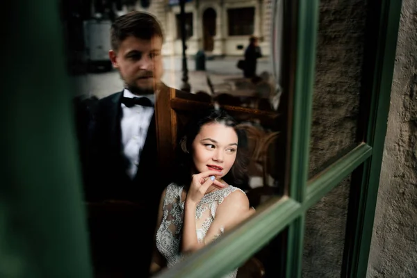 Kafede otururken damat gelin, dışarıdan görünüyor.