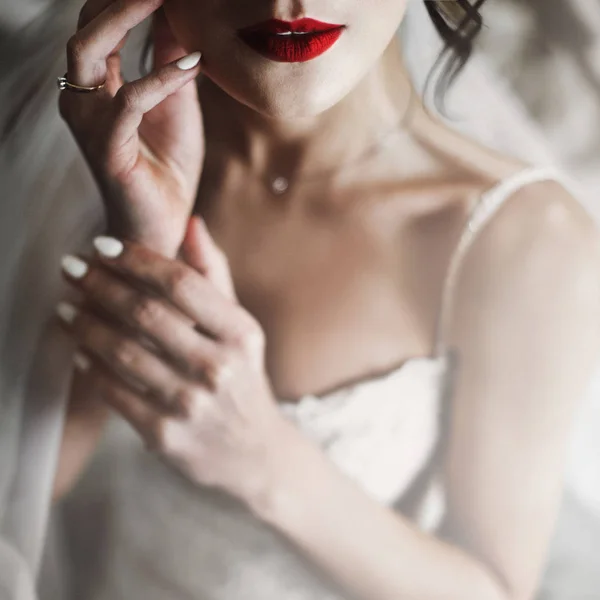 Bride holds her hands before tender red lips — Stock Photo, Image