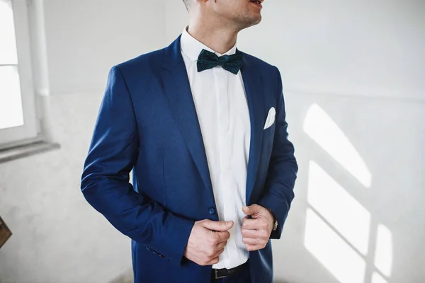 Cheerful groom puts on blue jacket — Stock Photo, Image