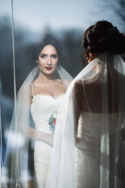 Reflection of gorgeous bride in the panoramic window