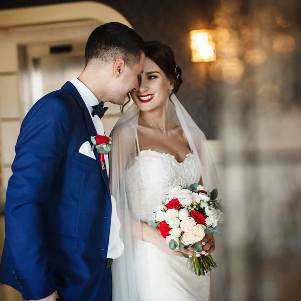 Улыбающаяся свадебная пара стоит в светлом зале — стоковое фото