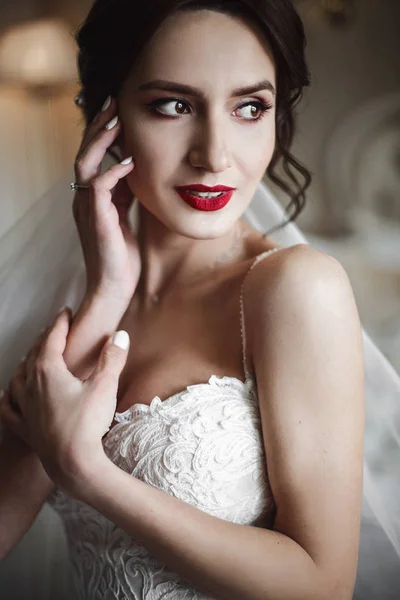 Bride holds her hands before tender red lips — Stock Photo, Image