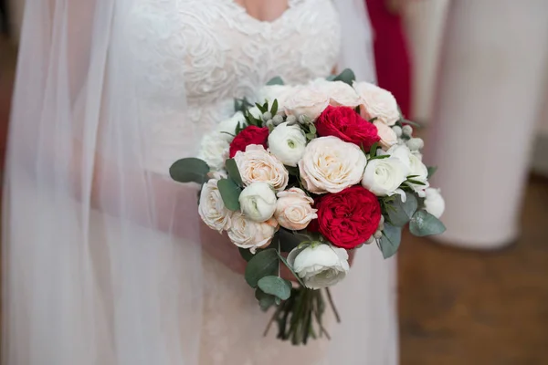 Lindo buquê de casamento de flores vermelhas e brancas no han da noiva — Fotografia de Stock