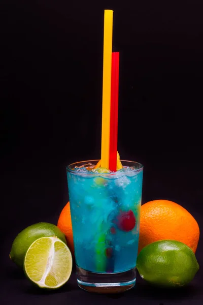 Cóctel azul con cerezas, mango, naranja, lima, pomelo sobre un fondo aislado — Foto de Stock