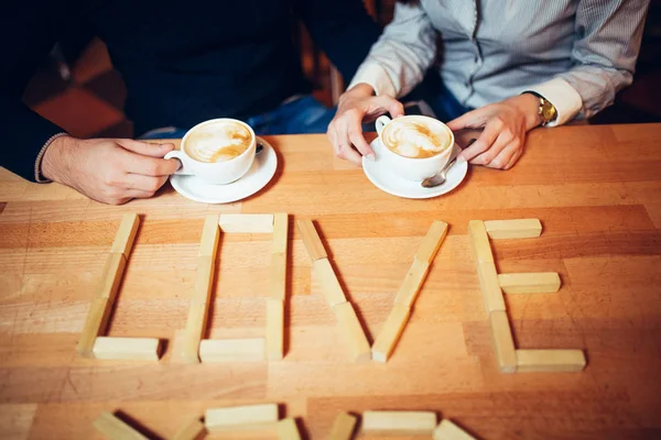 Ein paar Hände Kaffee auf einem Holztisch — Stockfoto