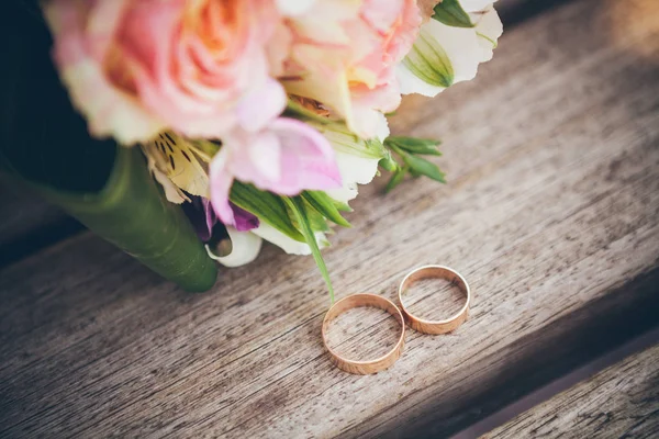 Anillo de boda desde la parte superior sobre fondo de madera. Ramo de boda — Foto de Stock