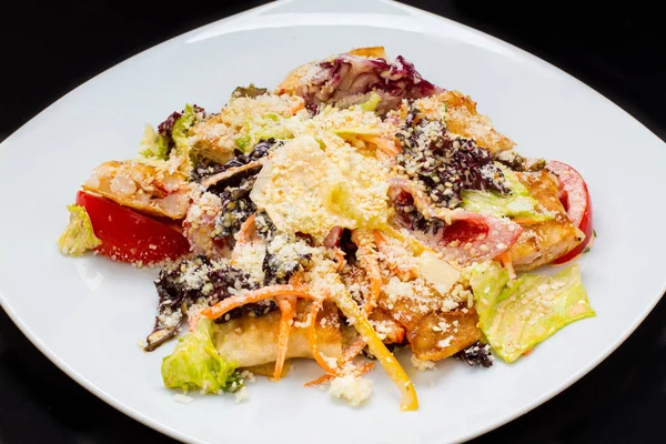 Ensalada caliente con queso, pescado, verduras en un plato blanco — Foto de Stock