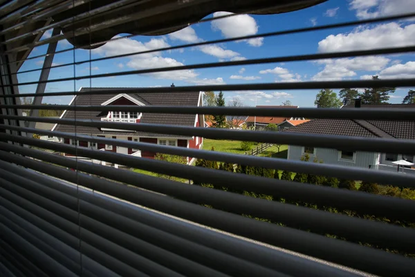 Uitzicht vanuit het raam door middel van de blinds — Stockfoto