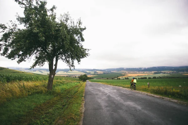 Il ragazzo sulla bicicletta viaggia in Slovacchia. Casco blu, zaino verde, occhiali , — Foto Stock